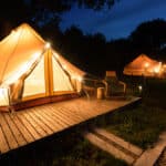 glamping yurt with wooden sidewalks and decorative lights on yurt